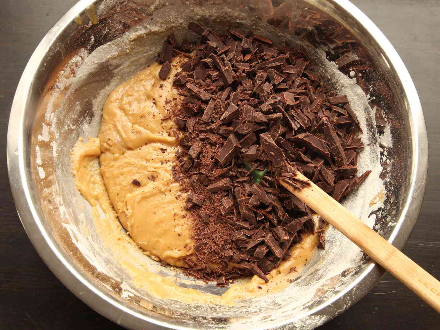 一碗饼干面团和切碎的巧克力准备混合巧克力片饼干。gydF4y2Ba