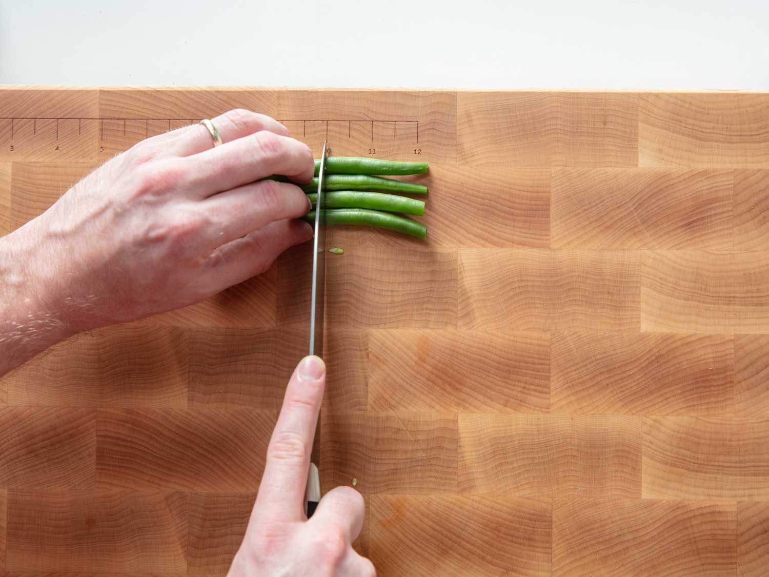 Cutting green beans on the BoardSmith Serious Eats cutting board.