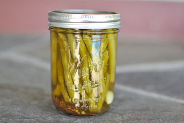 A small mason jar of spicy dilly green beans