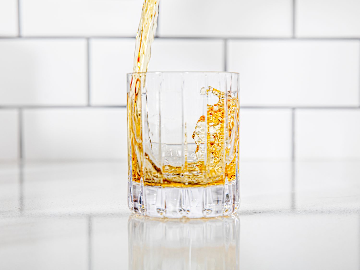 whiskey being poured in a rocks glass