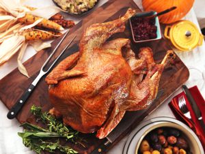A whole, golden brown roast turkey on a cutting board