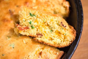 Cross-section view of cheddar, bacon, and scallion cornbread in cast-iron skillet