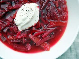 A bowl of vegetarian borscht with a dollop of sour cream on top.