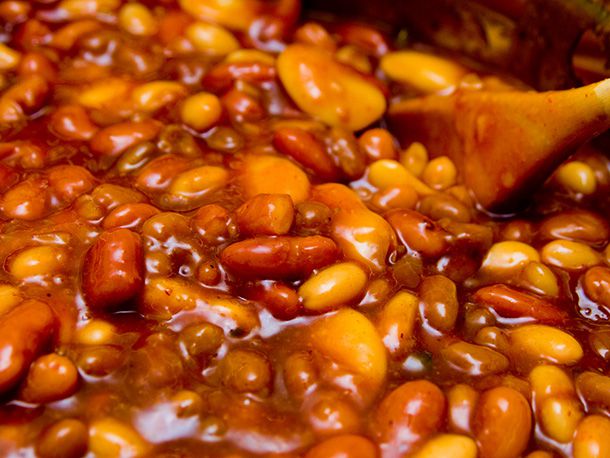 A close-up of Mike Mills' tangy pit beans being stirred in a pot.