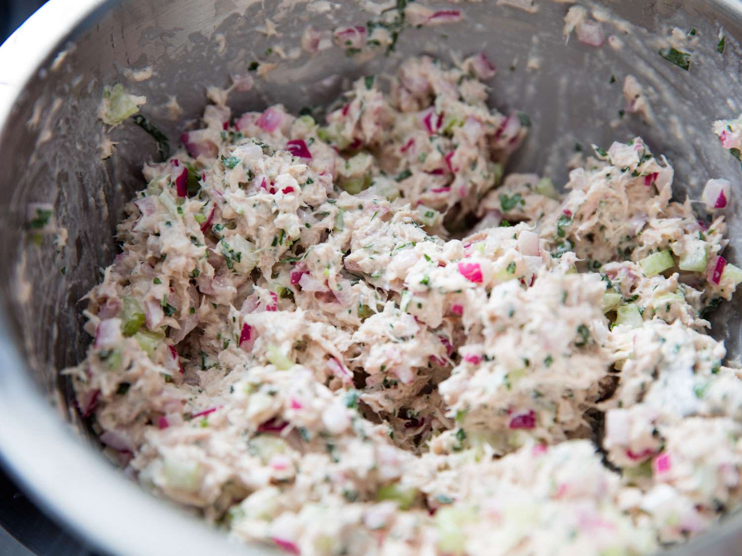 Close-up of the finished tuna salad in a mixing bowl.