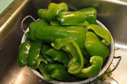 Chunked up green peppers in a colander.