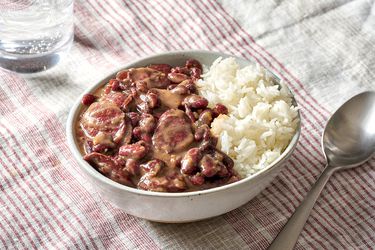 New Orleans-Style Red Beans and Rice served in a bowl on a patterned table cloth.