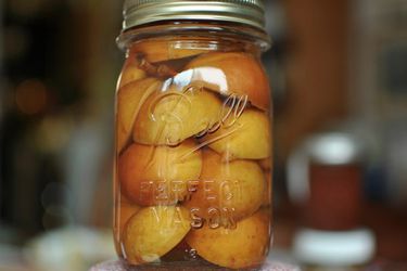 Large canning jar filled with pickled seckel pears