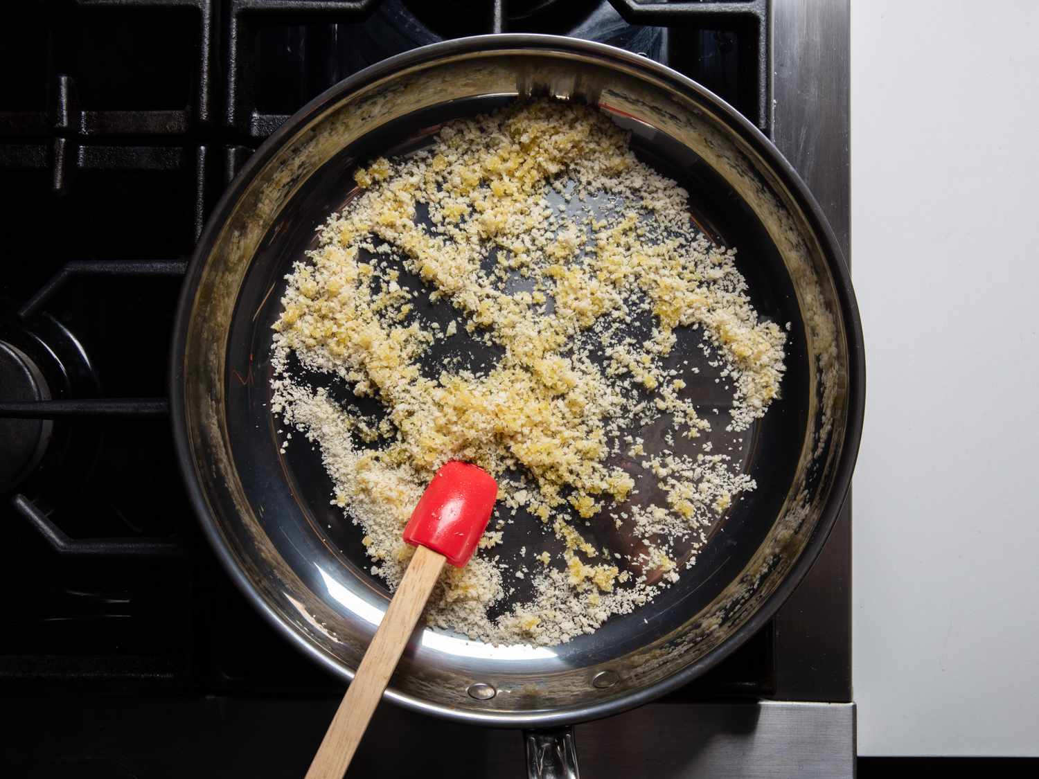 将面包屑放入煎锅中，与橄榄油轻微混合。