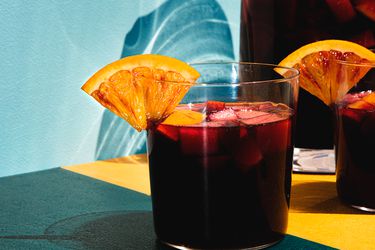 A glass of sangria adorned with an orange wedge.