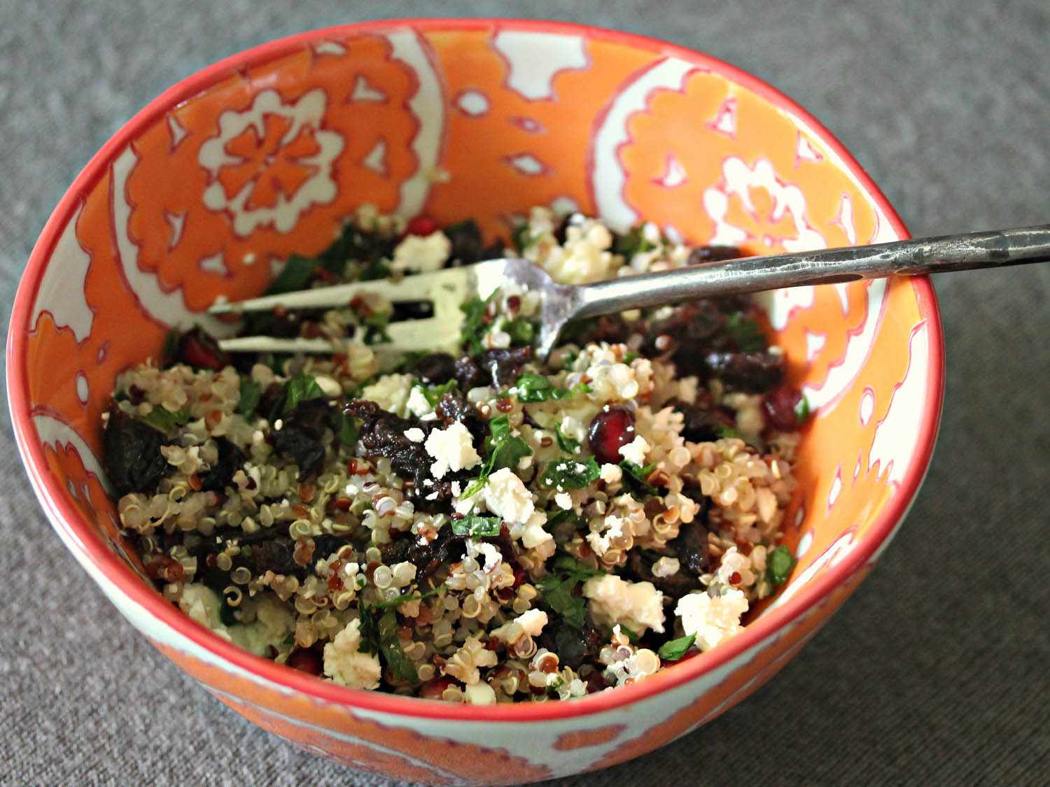 A bowl of quinoa salad with dried tart cherries, mint, and feta in lemon-sumac vinaigrette