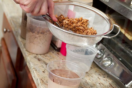 Straining milk-soaked chocolate cereal