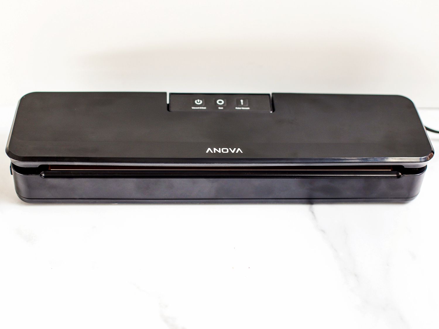The Anova Precision vacuum sealer on a marble countertop