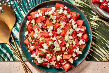Watermelon, feta, and mint salad in a bowl on a colorful tropical print napkin