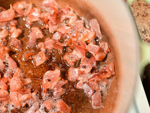 Chopped bacon rendering in a pot.