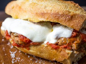 An Italian American meatball sandwich with melted mozzarella cheese and tomato sauce.