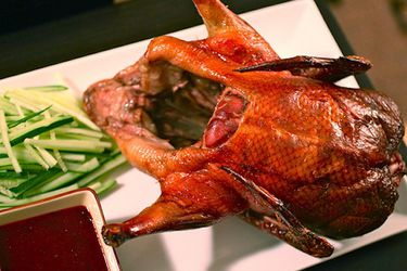 Whole roasted Peking duck with plum sauce and cucumbers.