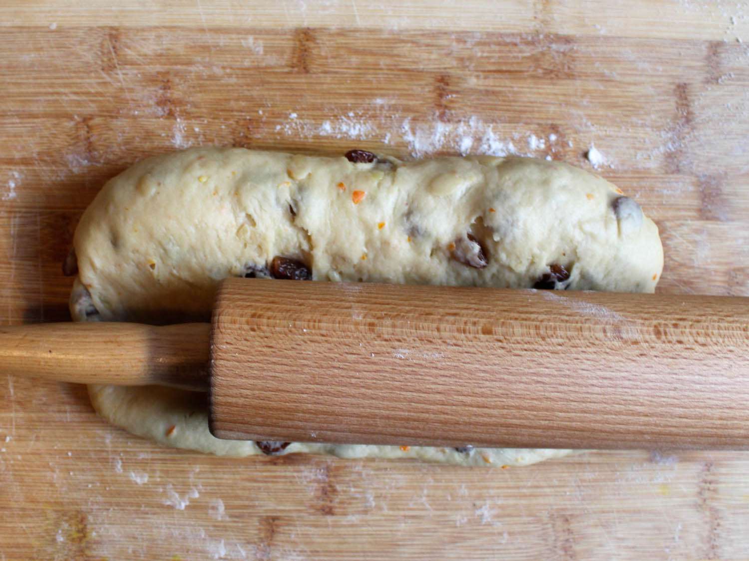 用擀面杖在未煮熟的偷来的面团上，在木制工作台上做一个杏仁蛋白软糖沟槽。