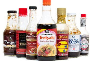 Seven bottles of different brands of teriyaki sauce