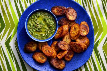Overhead view of maduros on a blue plate with mint mojos on a striped green background