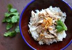 Taiwanese turkey rice topped with fried shallots and cilantro, in a red and blue bowl.