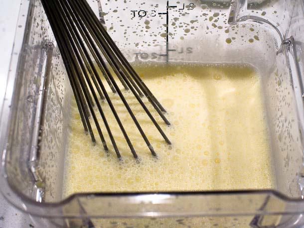 一起搅拌奶油成分基础在一个方形的塑料开云体育波胆容器。
