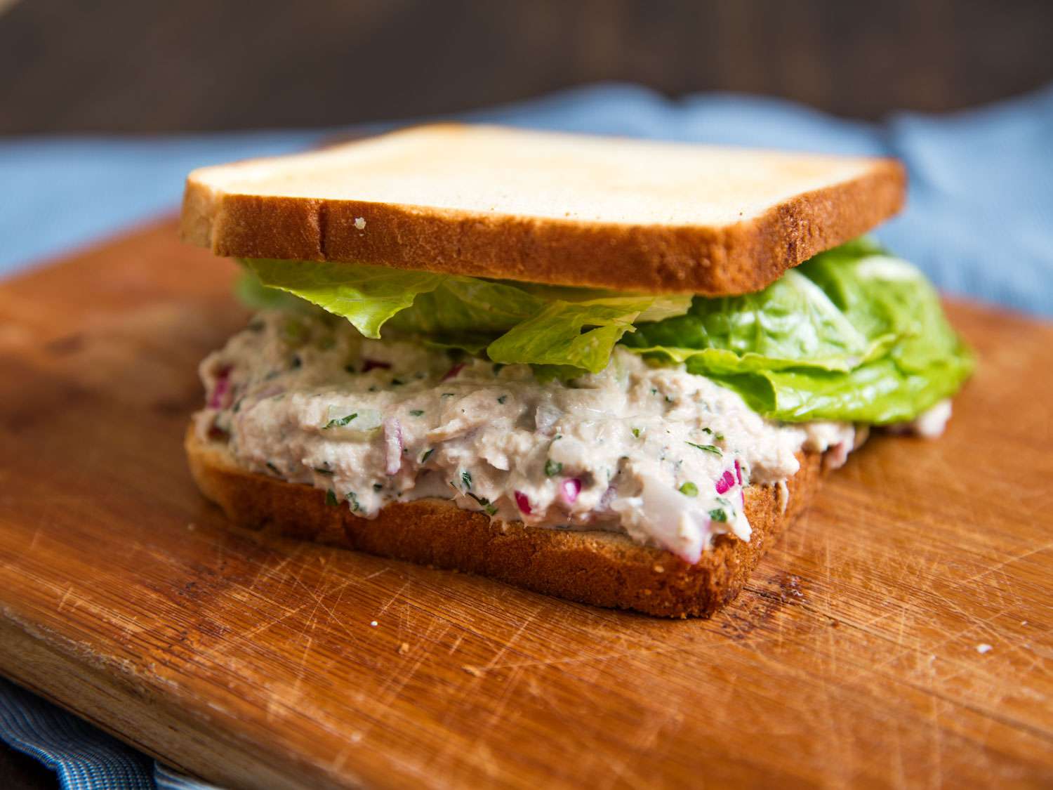 Close-up of a tuna salad sandwich, made with toasted white bread and lettuce.