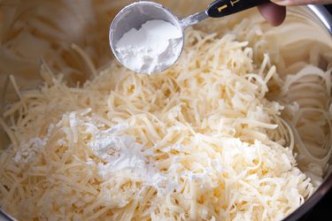 Cornstarch being added to cheese